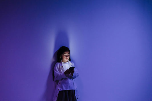 Young Girl Using Smartphone while Leaning on the Wall