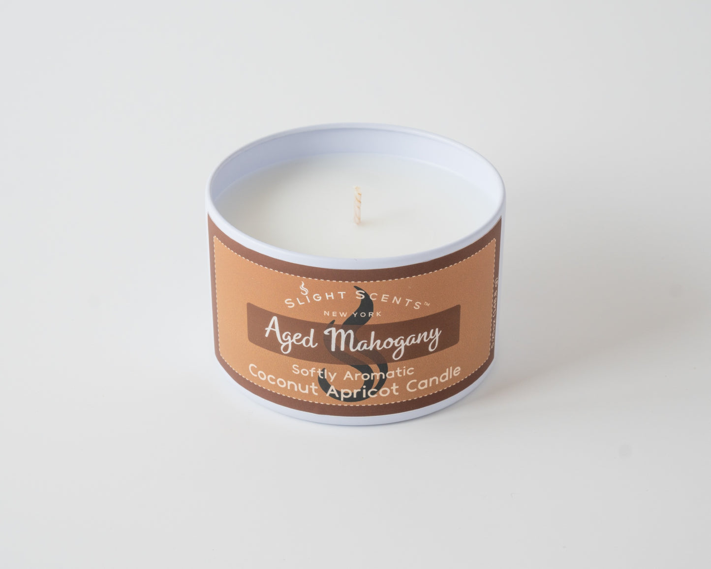 Aged Mahogany Coconut Apricot Candle By SlightScents New York in a white metal tin on a white background without a lid.