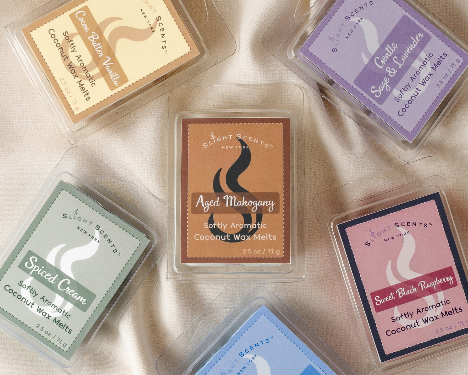 Assorted color Slight Scents wax melts on a tan background.