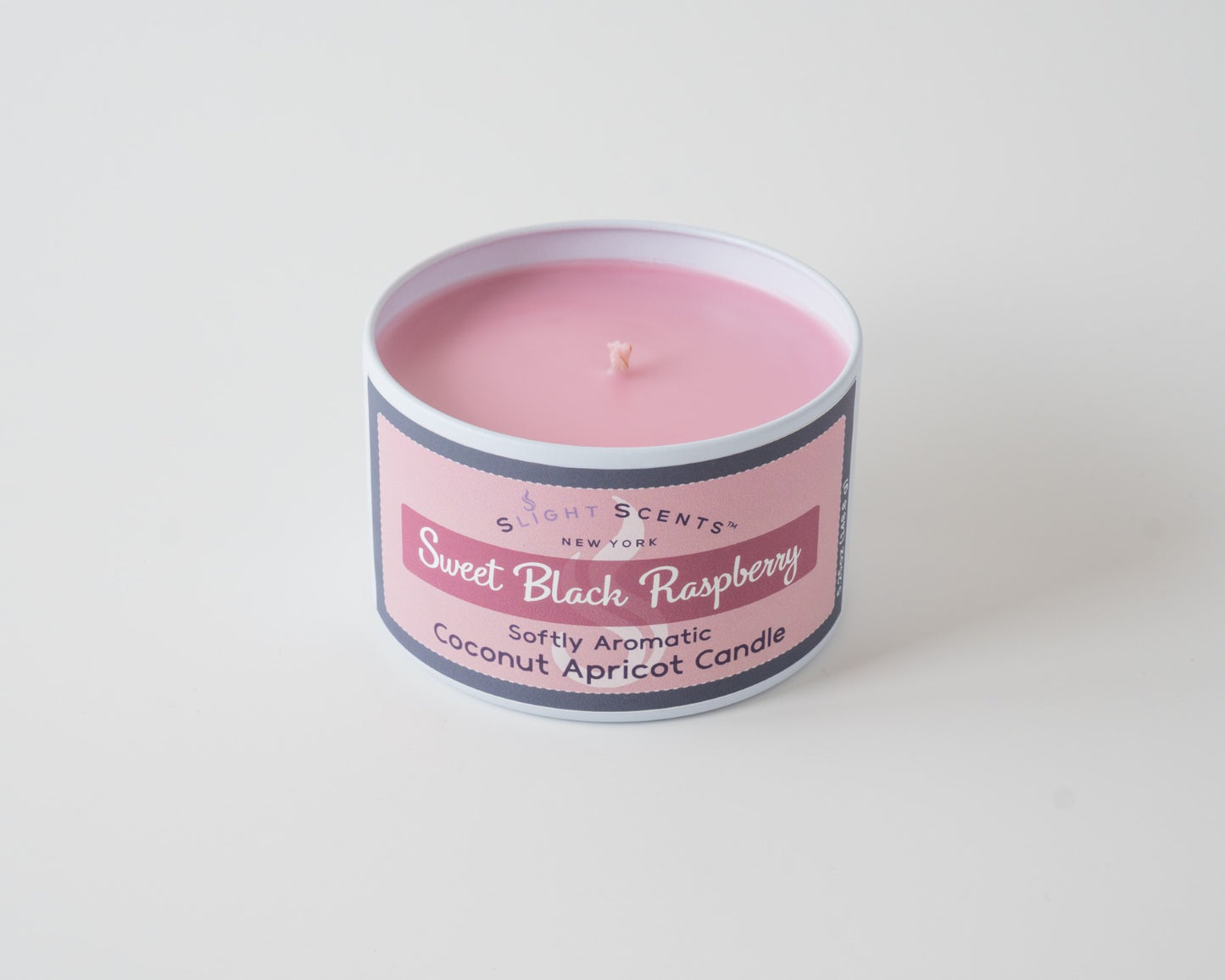 Sweet Black Raspberry Coconut Apricot Candle By Slight Scents New York in a white metal tin on a white background without a lid.