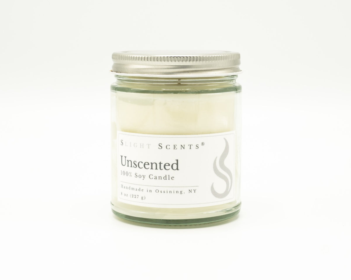 Front view of an unscented soy candle with white label, undyed wax, and silver metal lid in a glass jar.