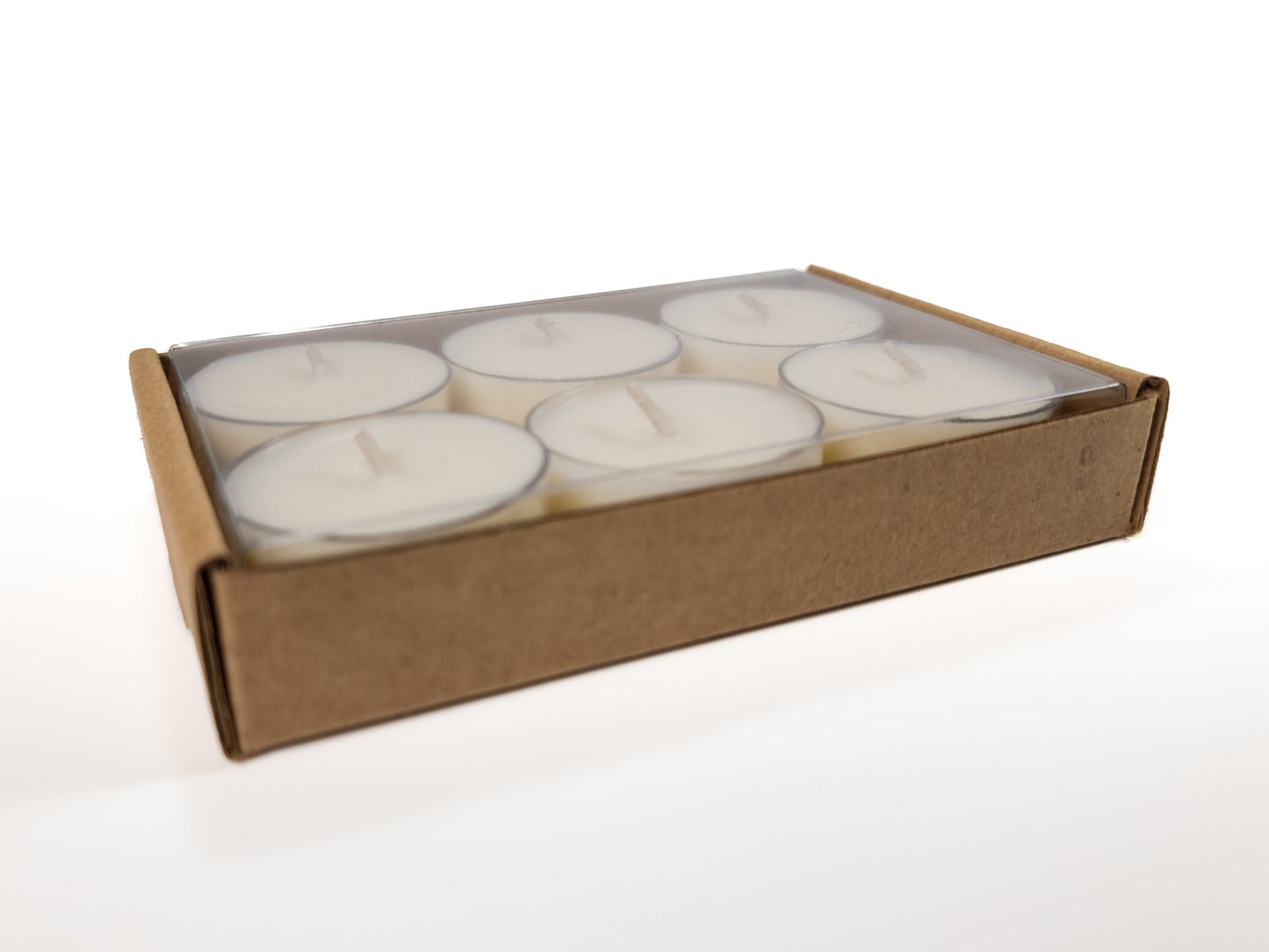 A 6-pack of 100% soy tealights neatly arranged in a cardboard box with a clear plastic cover, showcasing the tealights inside. 3.42oz / 97g.