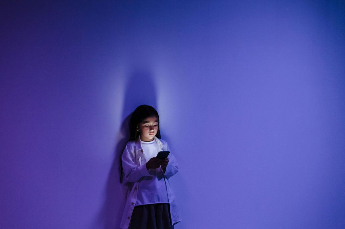 Young Girl Using Smartphone while Leaning on the Wall