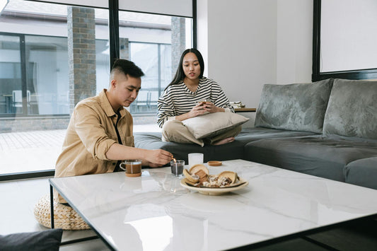 Man and Woman Sitting on the Couch Lighting a Candle