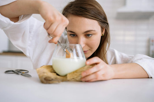 Woman trimming a wooden wick on a candle.