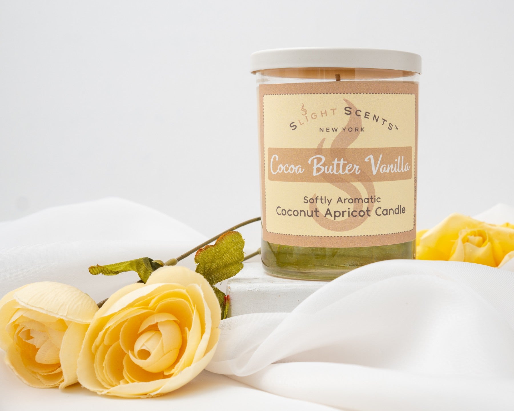Cocoa Butter Vanilla candle with yellow flowers on a white background.