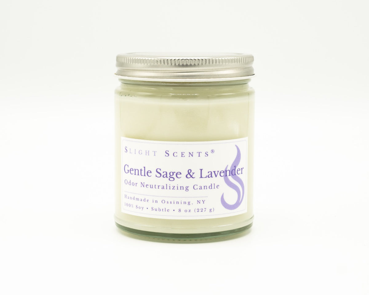 Front view of an Gentle Sage and Lavender odor neutralizing candle with white label, undyed wax, and silver metal lid in a glass jar. 