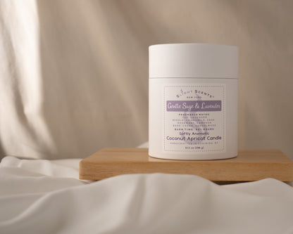 Gentle Sage & Lavender 10.5 oz candle white tube container on a wooden tray against a cloth background.