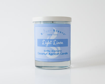 Light Linen Softly Aromatic Coconut Apricot Candle by Slight Scents New York against a white background.
