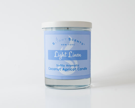 Light Linen Softly Aromatic Coconut Apricot Candle by Slight Scents New York against a white background.