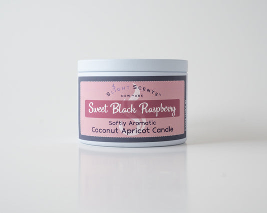Sweet Black Raspberry Coconut Apricot Candle By Slight Scents New York in a white metal tin on a white background.