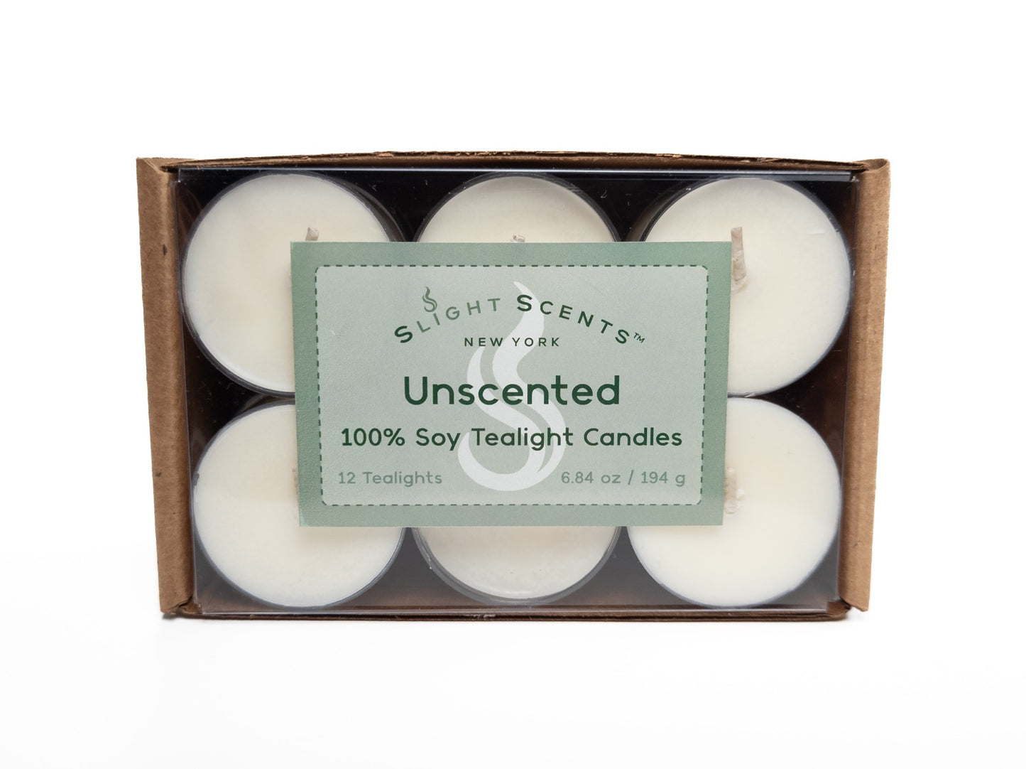 A 12-pack of 100% soy tealights neatly arranged in a cardboard box with a clear plastic cover, showcasing the tealights inside. The packaging displays a green label that says "Slight Scents New York Unscented 100% Soy Tealight Candles." 6.8oz 194g. Box turned on its side.